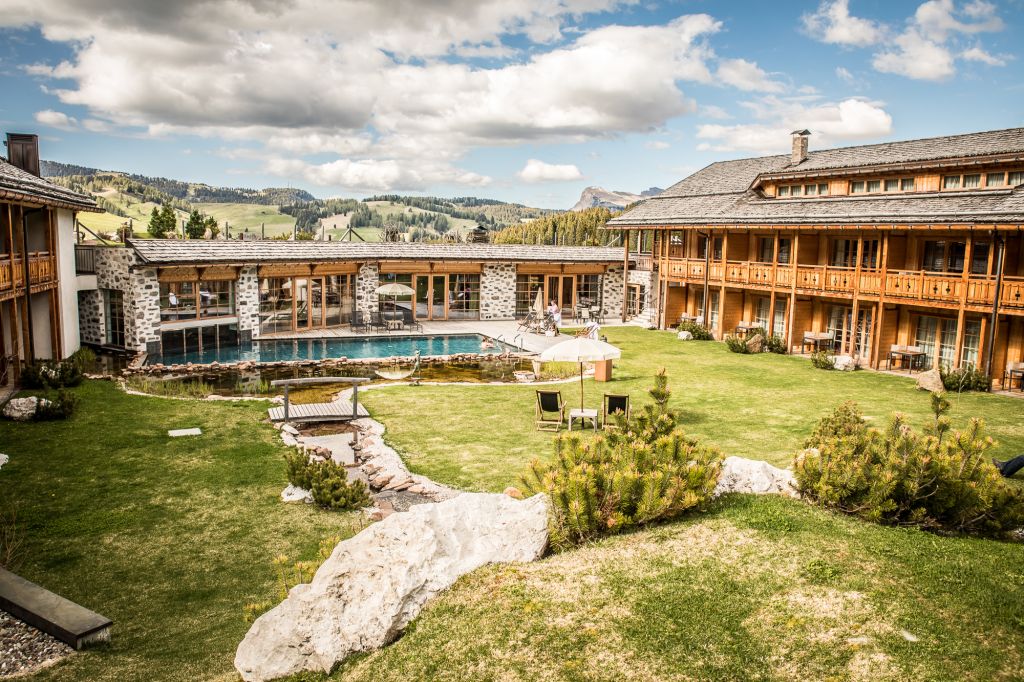 Außenanlage mit Outdoorpool im Sommer (Tirler-Dolomites Living Hotel)
