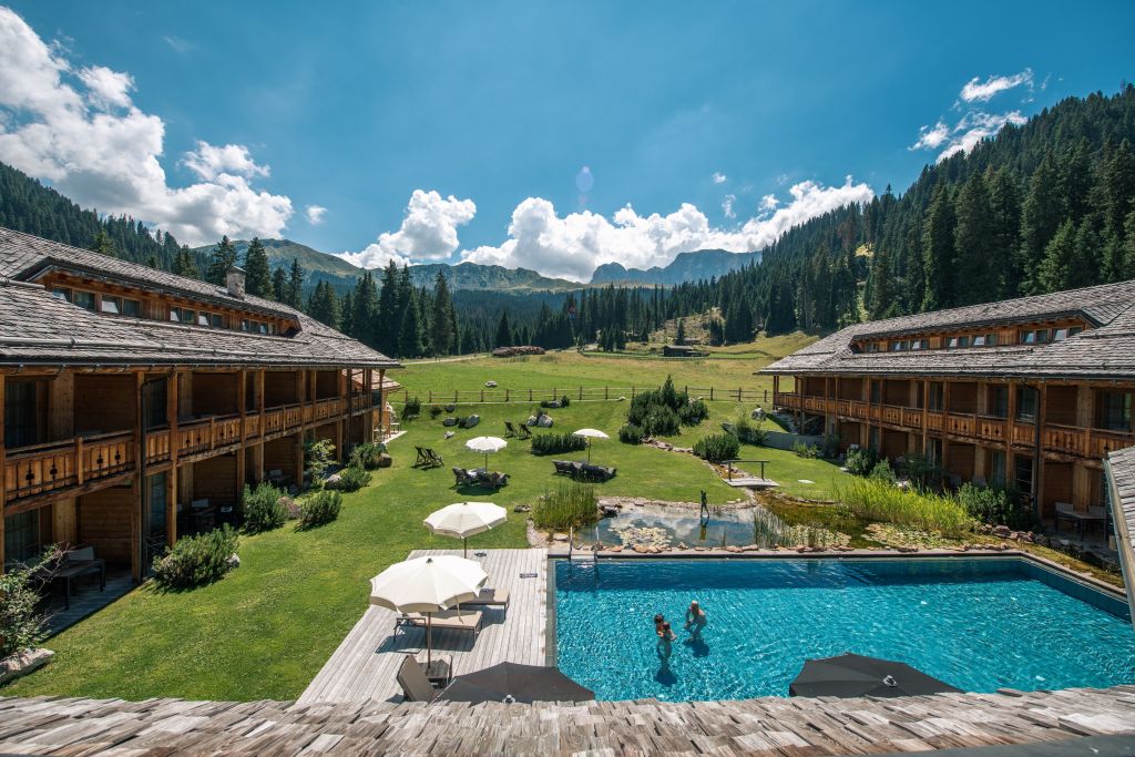 Hotelansicht mit glänzender Poolanlage (Tirler-Dolomites Living Hotel)