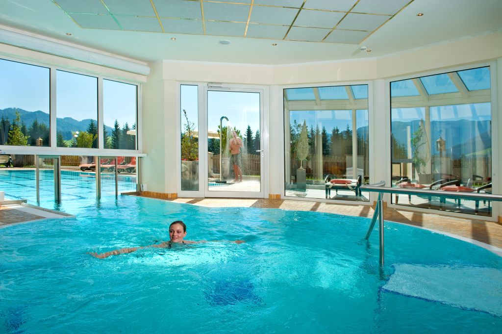 Indoorpool mit Aussicht im Hotel Alpina
