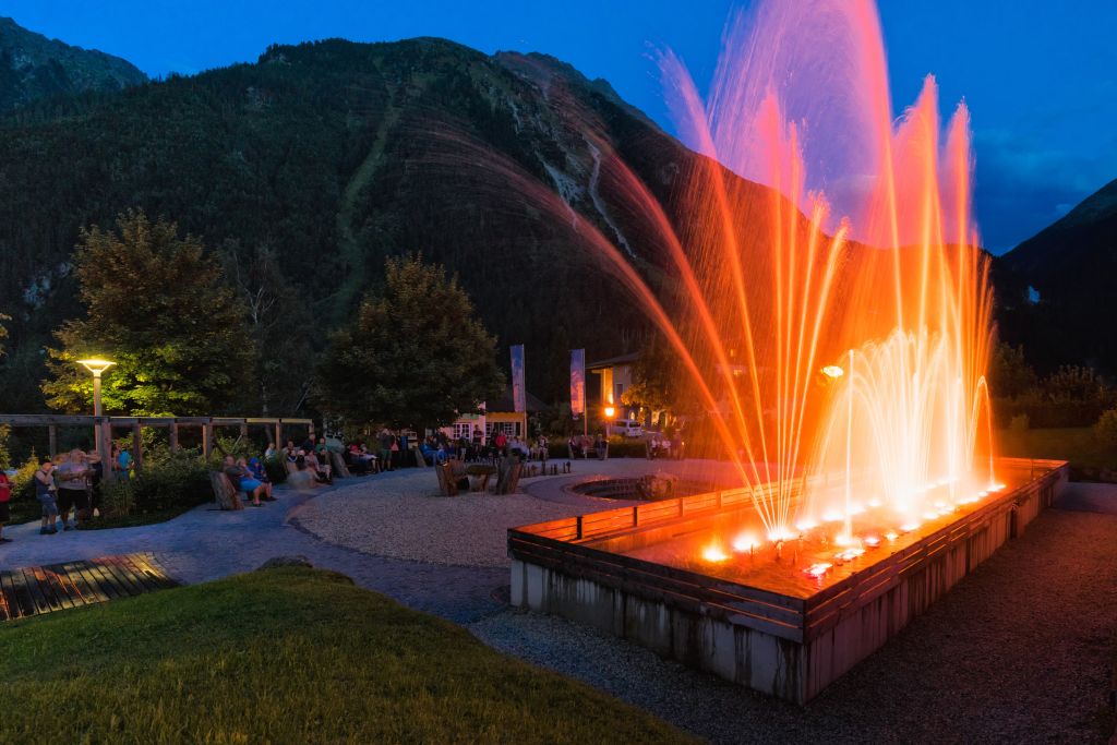 Zuschauer genießen Wasserfestspiele im Sommer bei Dämmerung (Tourismusverband Krimml)