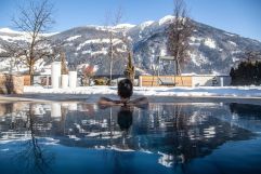 Blick aus dem Pool auf die verschneiten Berge (Held Hotel &amp; Spa)