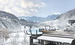 Das Hotel umgeben von einer winterlichen Landschaft (Quellenhof Luxury Resort Passeier)