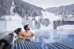 Entspannung im Pool mit Aussicht auf die verschneiten Berge (Das SeeMOUNT Superior Active Nature Resort)