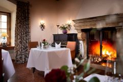 Gedeckter Tisch vorm romantischen Kamin (Schloss Hotel Mittersill)