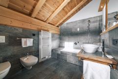Hochmodernes Badezimmer in dunklen Tönen (Tirler-Dolomites Living Hotel)