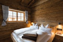 Schlafzimmer mit wohlduftendem Zirben-Kuschelbett im Kuschel-Chalet „s´gmietlenè“ (c) www.studiowaelder.com (Alpzitt Chalets)