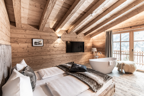 Schlafzimmer mit freistehender Wohlfühlwanne und Balkon (c) ratko-photography (Benglerwald Berg Chaletdorf)